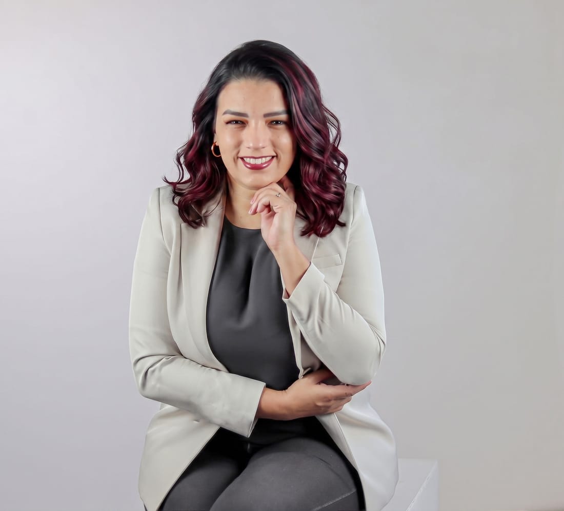 Andrea Vronik con blazer claro, sonriendo, retrato corporativo